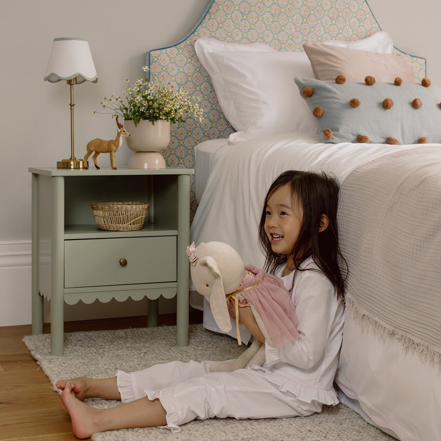 girl having a playful moment next to her bed